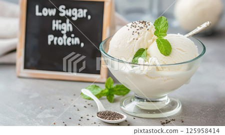 Protein-rich, low-sugar ice cream scoops garnished with chia seeds, mint leaves near chalkboard showing nutritional details Protein-rich, low-sugar ice cream scoops garnished with chia seeds, mint leaves near chalkboard showing nutritional details 125958414