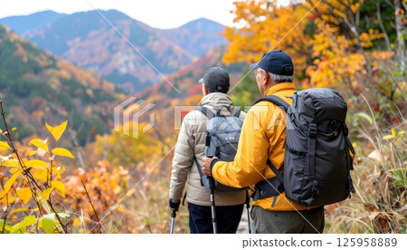 Elderly Couple Enjoys Hiking in Autumn Colored Mountains 125958889
