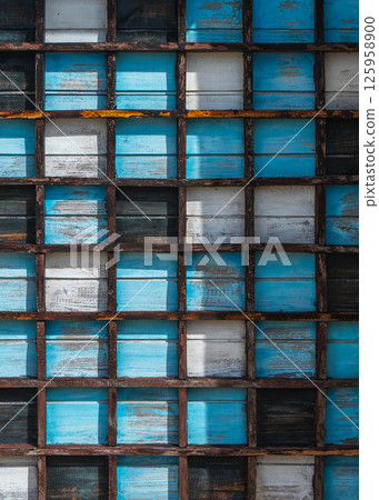 Wooden grid with colorful weathered blue and white panels, background, texture 125958900