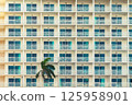 Modern hotel with rows of balconies creates a geometric pattern. 125958901