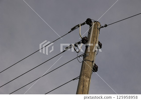 A tall wooden pole with wires on top of it 125958958