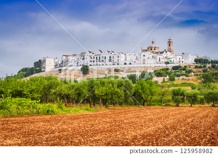 Locorotondo, Italy is a charming Apulian hilltop town known for whitewashed houses and circular layout 125958982
