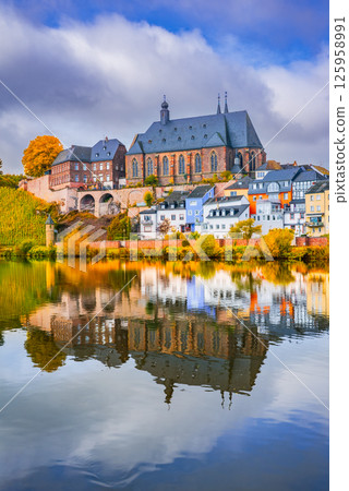 Saarburg, Germany. Water reflection landscape with charming old town on Saar River. 125958991