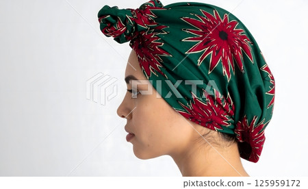 A woman wearing a green and red flowery head scarf 125959172