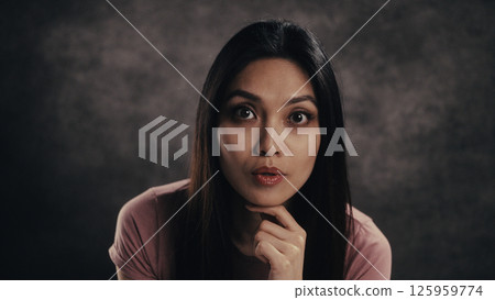 Thoughtful woman contemplating in dim light 125959774