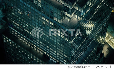 Modern glass skyscraper illuminating Manhattan at night 125959791