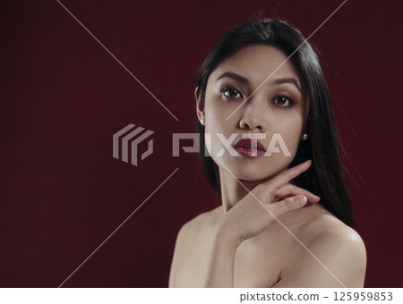 Beautiful Asian Woman Posing in Studio with Burgundy Background Beautiful Asian Woman Posing in Studio with Burgundy Background 125959853