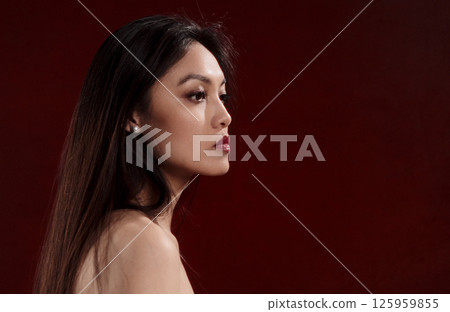Young Asian Woman Posing in Studio with Red Background Young Asian Woman Posing in Studio with Red Background 125959855