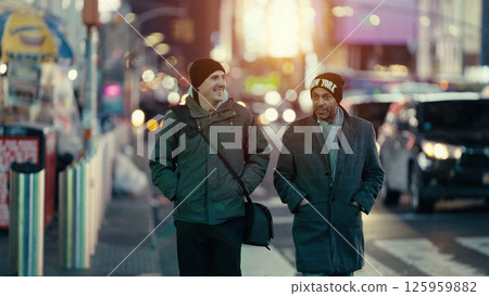 Two men walking and talking on a Manhattan street at sunset Two men walking and talking on a Manhattan street at sunset 125959882