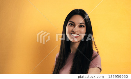 Young Asian Woman Smiling on Yellow Background with Copy Space 125959960