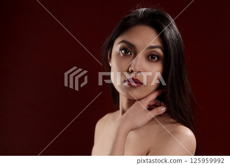 Young Asian Woman Posing in Studio with Hand on Neck 125959992