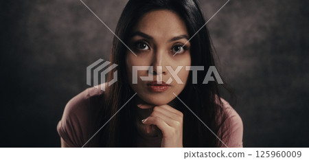 Thoughtful Woman Posing in Studio Setting 125960009