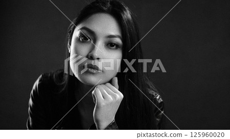 Thoughtful woman posing in dramatic lighting 125960020