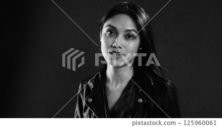 Thoughtful Woman in Black Leather Jacket Posing Thoughtful Woman in Black Leather Jacket Posing 125960061