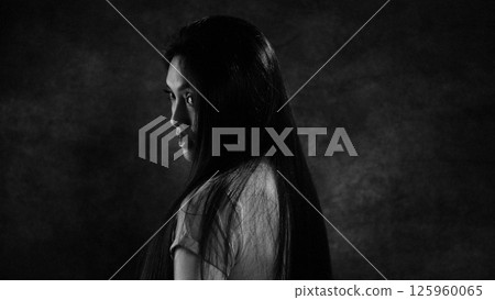 Mysterious Woman with Long Flowing Hair in Shadow 125960065