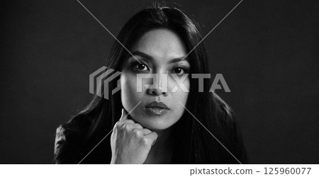 Thoughtful Woman Posing in Dramatic Lighting 125960077