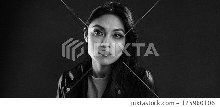 Young Asian Woman Posing with Leather Jacket and Long Hair in Black and White Young Asian Woman Posing with Leather Jacket and Long Hair in Black and White 125960106