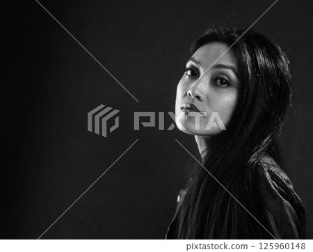 Thoughtful woman posing in dramatic lighting Thoughtful woman posing in dramatic lighting 125960148