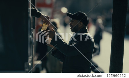 Homeless man receiving money from passerby in Manhattan 125960232