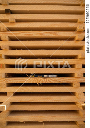 Front view of organized stack of wooden boards drying at lumberyard 125960266