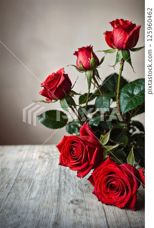 A Beautiful and Attractive Bouquet of Red Roses Positioned Elegantly on a Charming Wooden Table 125960462