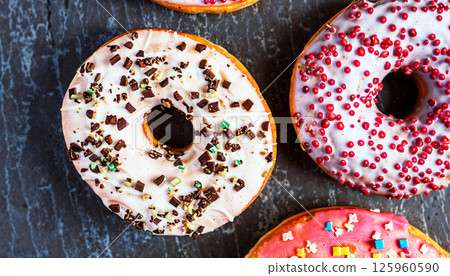 A Delicious Assortment of Colorful and Tempting Donuts Presented on a Rustic Background 125960590