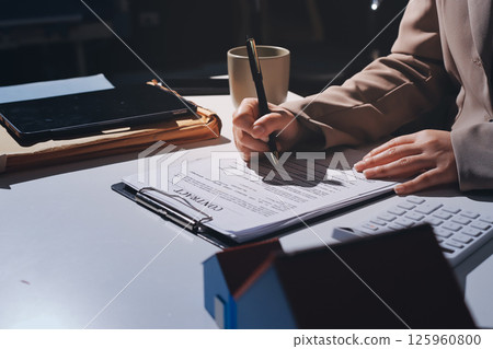 Female Real Estate Broker presenting and advised to model home and building project detail in the office, sign purchase sales contract, agreements concerned mortgage loan offer and insurance. 125960800