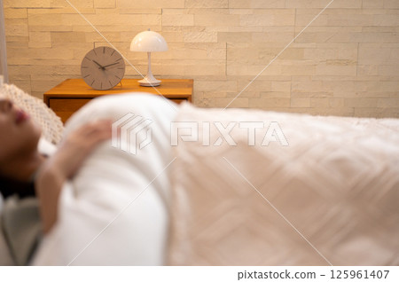 A woman has a peaceful moment as she closes her eyes and slowly sleeps in the morning light. 125961407