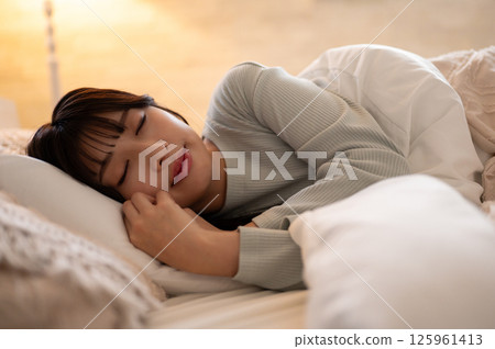 晚上，一名女子在臥室裡躺下，安靜地睡覺 125961413