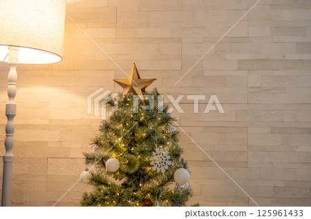 Simple indoor Christmas tree decorations illuminated with warm lights Simple indoor Christmas tree decorations illuminated with warm lights 125961433