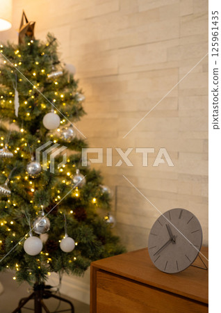 The wooden walls and the clock and tree on the table create a tranquil atmosphere. The wooden walls and the clock and tree on the table create a tranquil atmosphere. 125961435