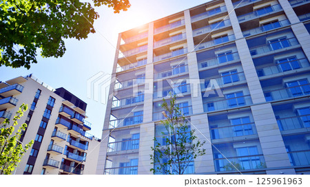 Eco apartment building saving energy and fresh air. Modern block of flats in green area, residential apartment and luxury house complex.  125961963
