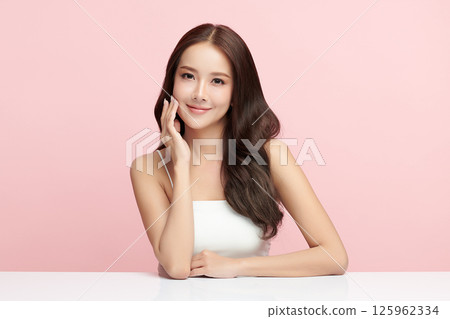 A beautiful young Asian woman with clean, fresh skin against a pink background. Skincare, facial treatment, cosmetology, beauty, and spa. An elegant portrait of an Asian woman. A beautiful young Asian woman with clean, fresh skin against a pink background. Skincare, facial treatment, cosmetology, beauty, and spa. An elegant portrait of an Asian woman. 125962334