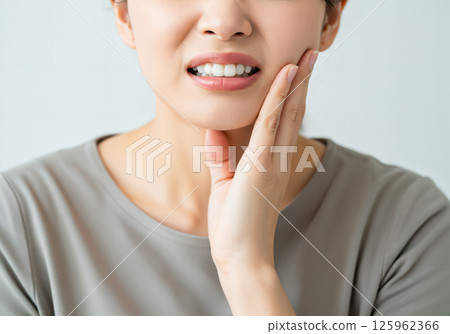 A woman with a painful expression due to toothache 125962366