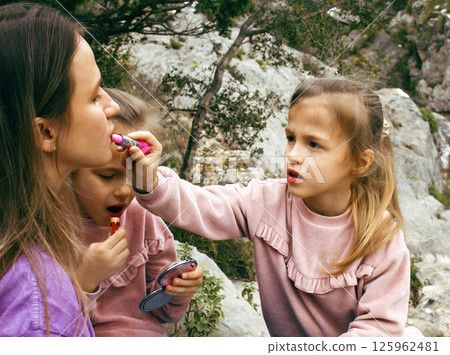 mother with daughter outside doing makeup having fun 125962481