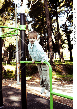 little cute girl having fun on training playground outside 125962533