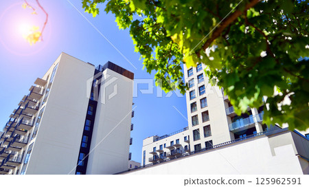 Eco apartment building saving energy and fresh air. Modern block of flats in green area, residential apartment and luxury house complex.  125962591