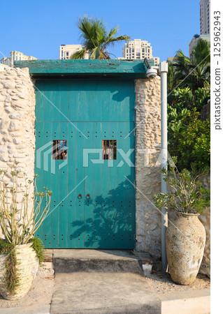 Blue wooden doors gates with metal round handles Blue wooden doors gates with metal round handles 125962943