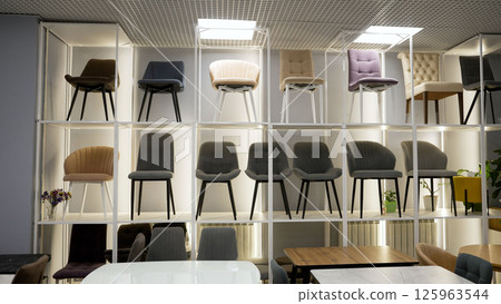Modern chairs displayed on shelves in furniture store Modern chairs displayed on shelves in furniture store 125963544