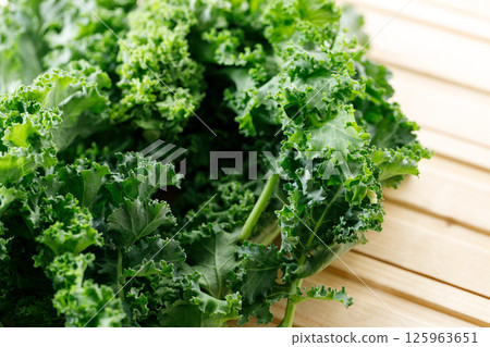 Fresh green Kale leaf salad vegetable on wooden background. Fresh green Kale leaf salad vegetable on wooden background. 125963651