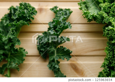 Fresh green Kale leaf salad vegetable on wooden background. 125963654