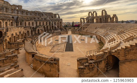 Entrance to ancient african Roman Colosseum amphitheatre arena panorama with ruins and columns, in subset time El Jem, Mahdia, Tunis Entrance to ancient african Roman Colosseum amphitheatre arena panorama with ruins and columns, in subset time El Jem, Mahdia, Tunis 125963903