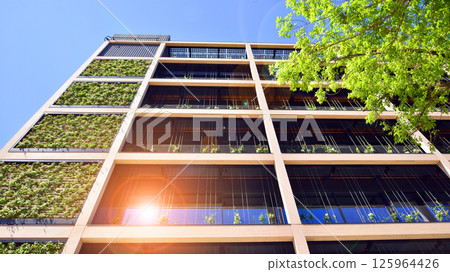 Modern city eco office building with tree. Detail shot of modern architecture facade,business concepts. Environment. Modern building and trees, double exposure. Modern city eco office building with tree. Detail shot of modern architecture facade,business concepts. Environment. Modern building and trees, double exposure. 125964426