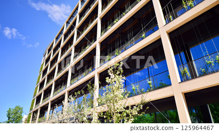 Modern city eco office building with tree. Detail shot of modern architecture facade,business concepts. Environment. Modern building and trees, double exposure. Modern city eco office building with tree. Detail shot of modern architecture facade,business concepts. Environment. Modern building and trees, double exposure. 125964467