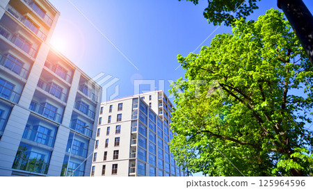 Eco apartment building saving energy and fresh air. Modern block of flats in green area, residential apartment and luxury house complex.  125964596