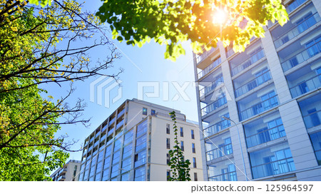 Eco apartment building saving energy and fresh air. Modern block of flats in green area, residential apartment and luxury house complex.  125964597