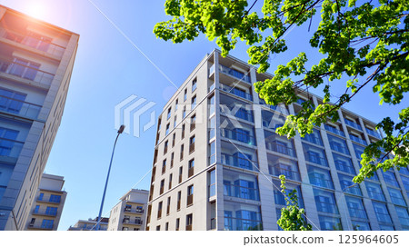 Eco apartment building saving energy and fresh air. Modern block of flats in green area, residential apartment and luxury house complex.  125964605