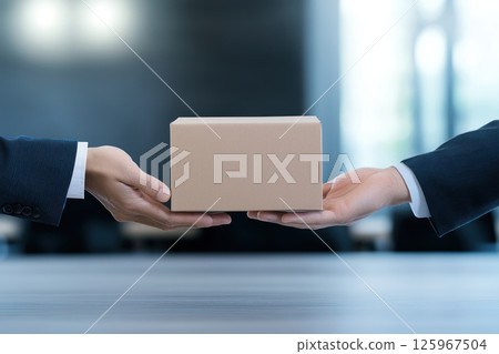 person in business attire is handing over package in modern office setting, showcasing professionalism and collaboration person in business attire is handing over package in modern office setting, showcasing professionalism and collaboration 125967504