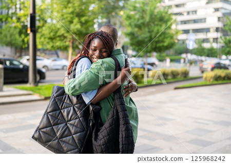 Happy black wife greets husband with smile, family reunion outdoors. Siblings meet each other Happy black wife greets husband with smile, family reunion outdoors. Siblings meet each other 125968242