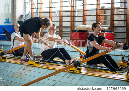 Attentive experienced coach instructs rower crew, correcting posture ensuring synchronized strokes 125968969